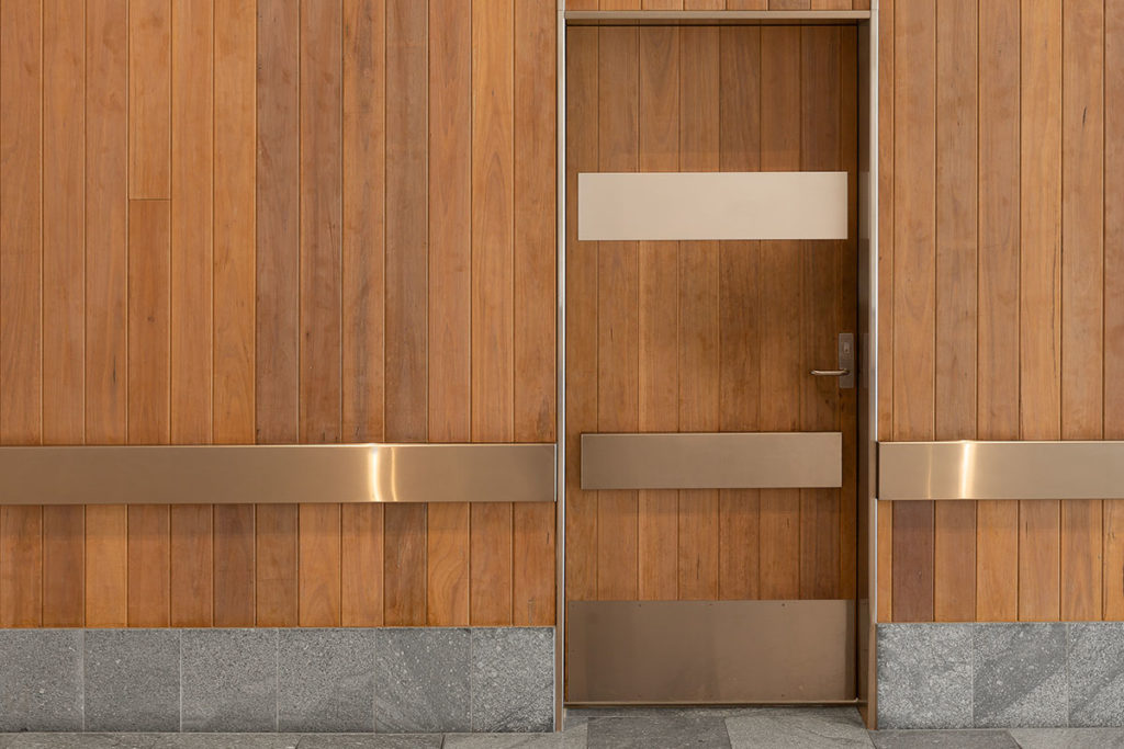 Timber clad walls matching a door with gold finishes.
